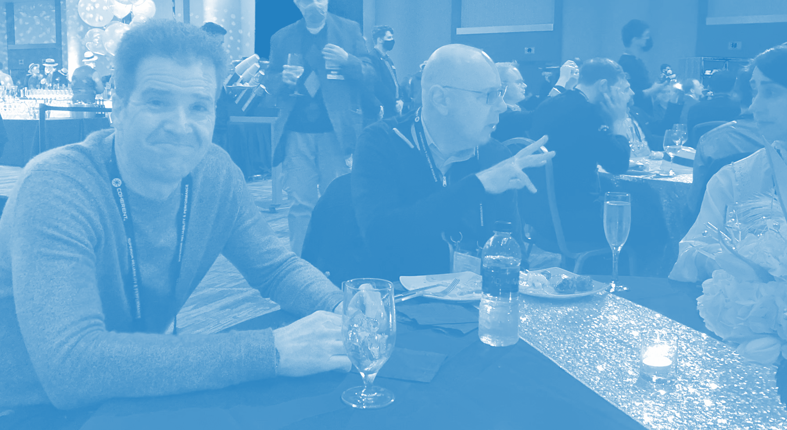 David Spinks and Gerard Zytnicki sit at a table at an SPIE 2022 party