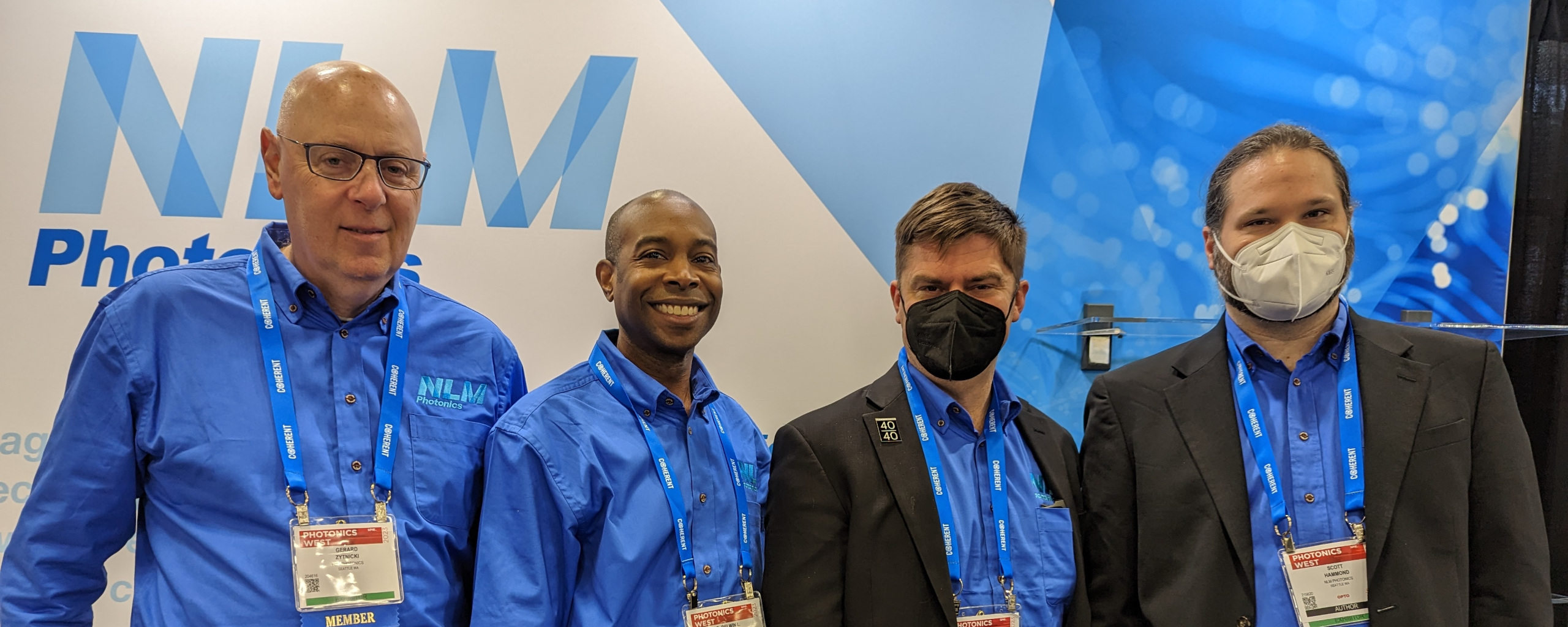 Gerard, Delwin, Lewis, and Scott in front of the NLM booth during Photonics West 2023