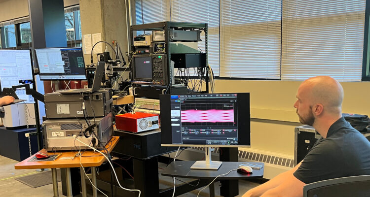 Dr. Scott Hammond and a Keysight employee tests NLM's PICs