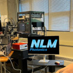 Scott and Keysight employee look at the results from NLM's PICs