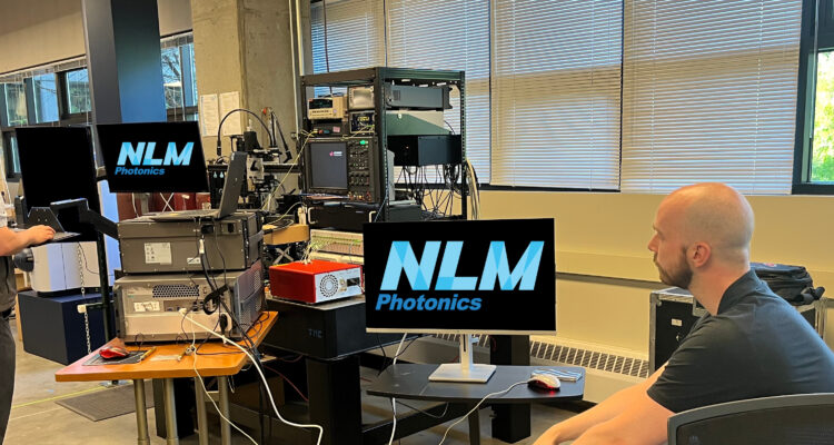 Scott and Keysight employee look at the results from NLM's PICs