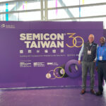 Gerard and Delwin stand in from the the SEMICON Taiwan 30 giant purple conference sign