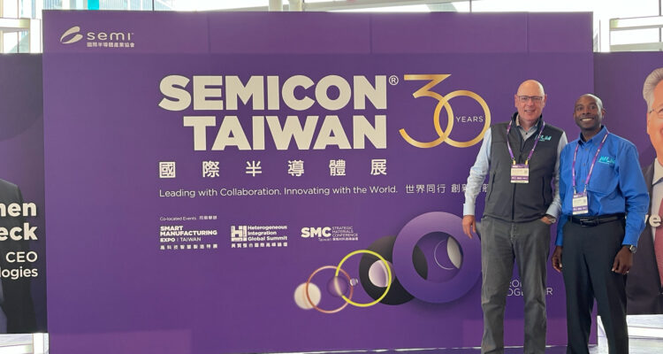 Gerard and Delwin stand in from the the SEMICON Taiwan 30 giant purple conference sign